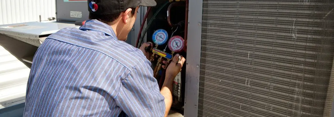HVAC technician servicing a condenser unit in Navarre