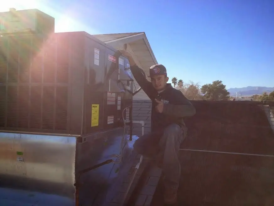 HVAC technician performing AC Tune-Up on a rooftop unit in Navarre